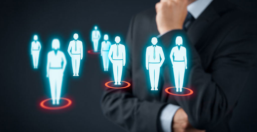 Bureau contemporain avec écran d'ordinateur affichant un tableau de bord flouté, clavier et carnet, éclairé par une large fenêtre
